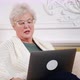 an Adult Woman with Gray Hair Works at a Laptop - VideoHive Item for Sale