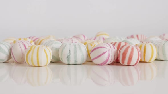 Sweet sugar bonbons on white background 4K tilting footage