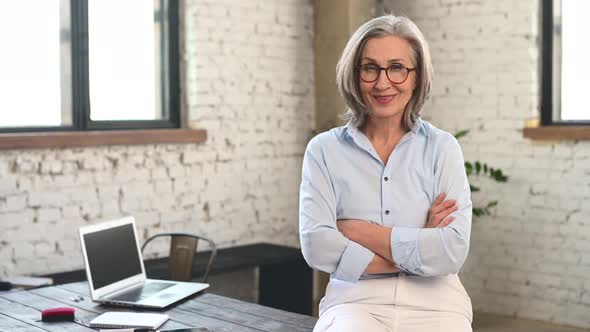 Positive Businesswoman Standing with Arms Folded