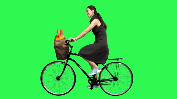 Beautiful Woman Riding a Bicycle Over a Green Screen, Looking Upwards Impressed