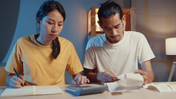 asia man and woman use calculator for calculate family budget debts monthly expenses.