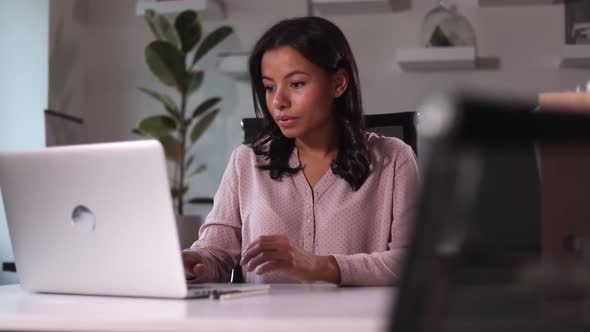 Businesswoman Looking at Laptop Screen and Sitting at Table in Modern Office Spbi