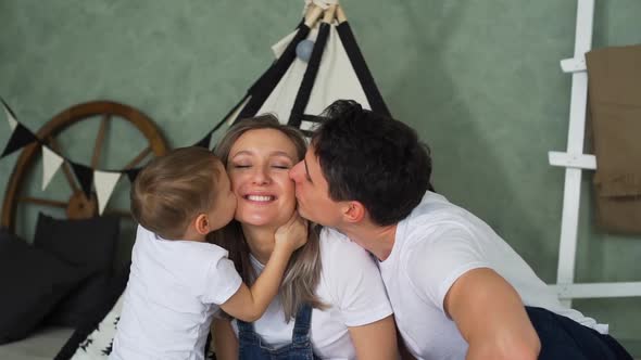 Little Boy with Father Kissing Pregnant Mother