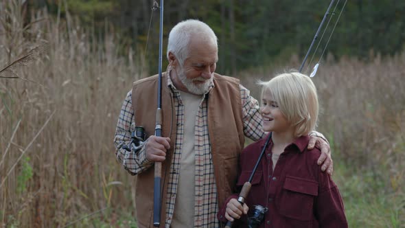 Teen Boy Enjoying Fishing Time with His Grandfather