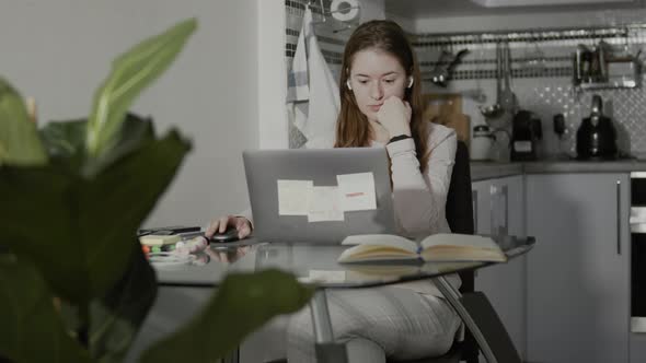 Contemporary Girl Browsing Laptop And Talking With Wireless Earphones