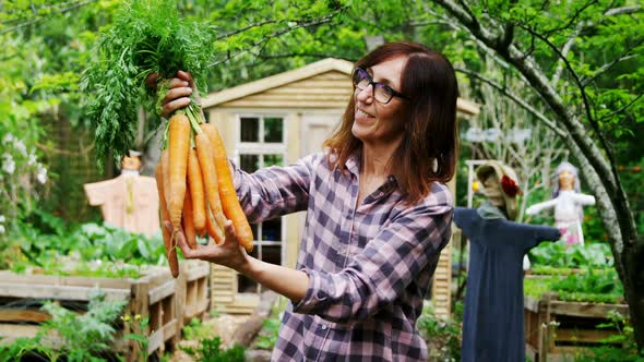 Mature woman holding carrot vegetable 