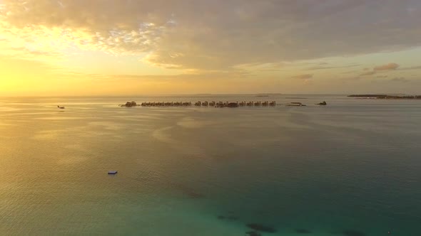 Aerial drone view of a seaplane landing at a tropical island in the Maldives
