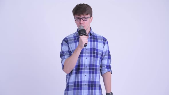 Happy Young Handsome Hipster Man Singing with Microphone