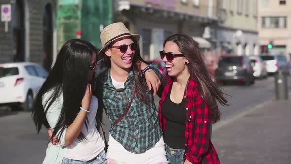 Three happy women walking in the city