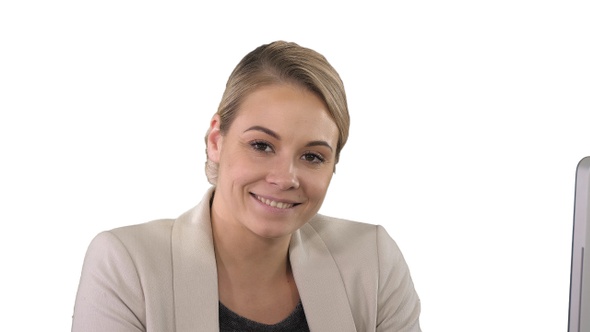 Smiling young woman looking at camera, white background