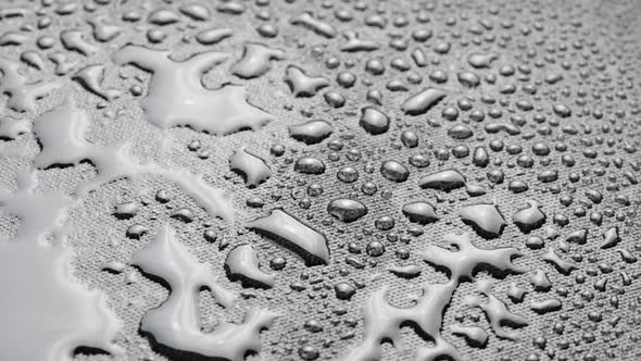 Spinning Closeup Background of Black Hydrophobic Fabric Covered with Water Drops