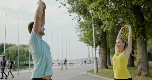 Positive Couple Happy Sportsman and Sportswoman Doing Warm Up Exercises for Arms During Fitness