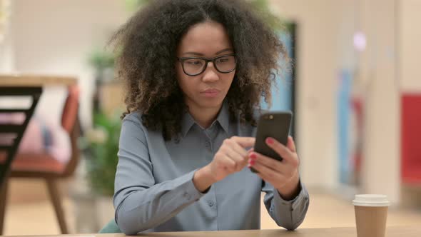 Young African Woman Using Smartphone at Work