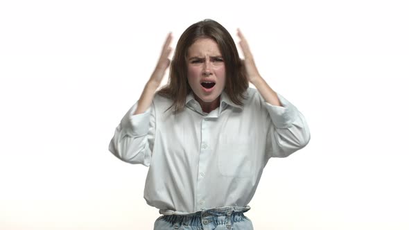 Attractive Young Woman with Long Hair Wearing White Collar Shirt Looking Frustrated and Distressed