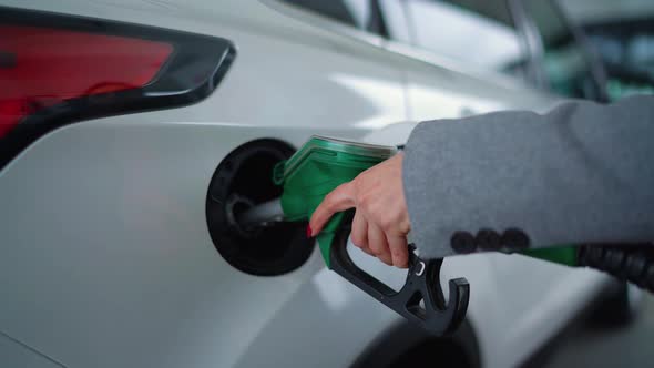 Woman Fills Petrol Into Her Car at a Gas Station Closeup