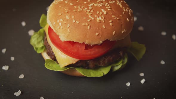 Delicious Cheeseburger on a Black Table with Salt Crystals