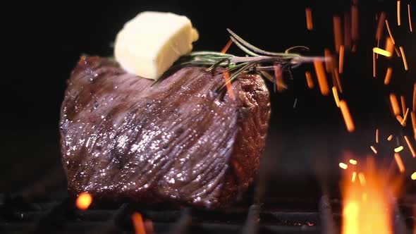 Meat with a piece of butter and rosemary is grilled. Barbecue meat