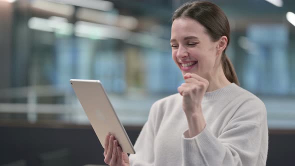 Excited Woman having Success on Tablet