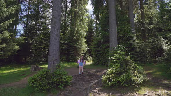 Girl on Swing Between Trees in Forest