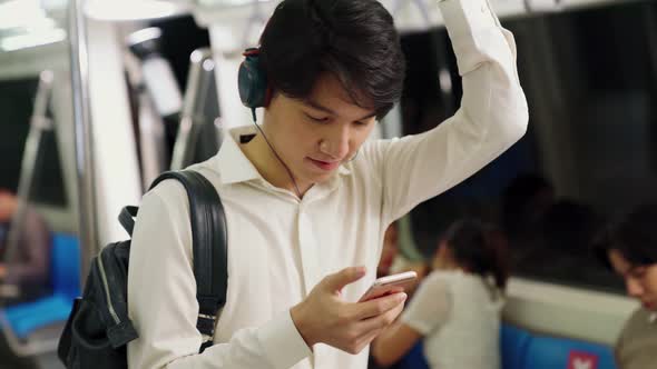 Businessman Using Mobile Phone on Public Train