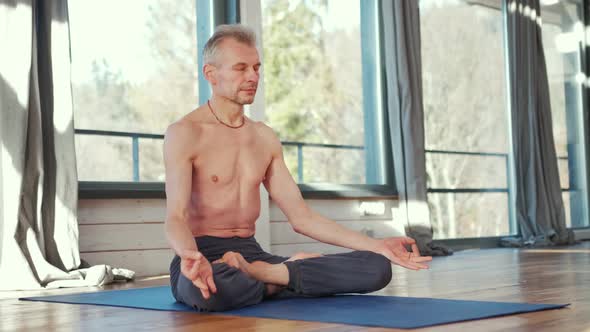 Mature Man Amongst Doing Power Yoga Exercises.