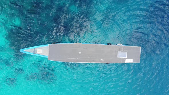 Aerial: Flying over boat coral reef turquoise water tropical island, scenic