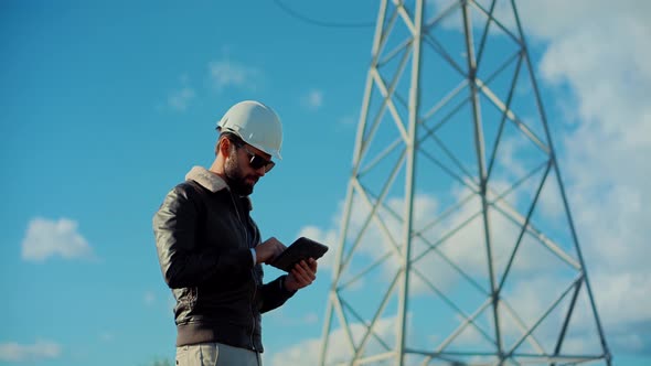 Constructor Inspect High Voltage Tower.Electrical Engineer In Helmet Maintenance Power Line Wire