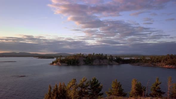 Rocky Pine Tree Islands and Blue Sky with Clouds at Sunset, Drone Aerial Wide Dolly In. Flying over