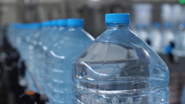 Close-up of five-liter bottles traveling on a conveyor belt for the camera
