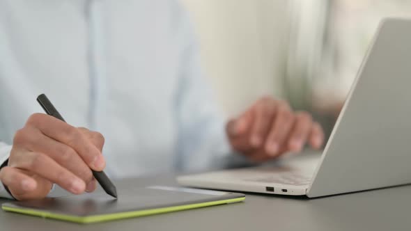 African Man Hands Designing on Tablet and Using Laptop