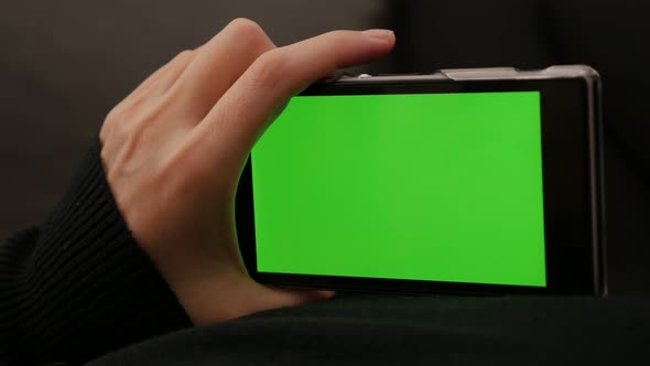 Content scrolling on mobile phone green screen display 4K 2160p UHD video - Woman holding smart phon