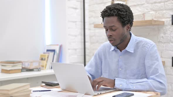 Sleepy African Man Working on Laptop