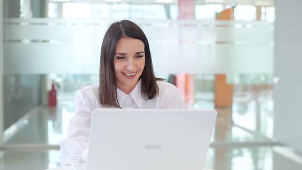 The Girl in the Office Talking on Video Call with a Laptop