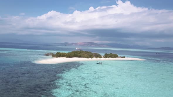 Aerial drone shot FPV of amazing turquoise ocean water with coral reefs and some boats in the backgr