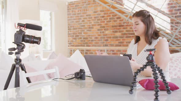 Caucasian vlogger woman doing video montage at home