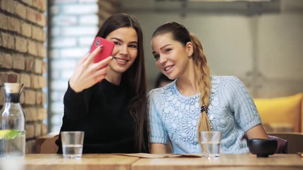 Two Women Friends Take a Mobile Selfie Shot in Cafe