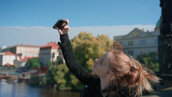 Young Woman On Charles Bridge Taking Selfie On Smartphone