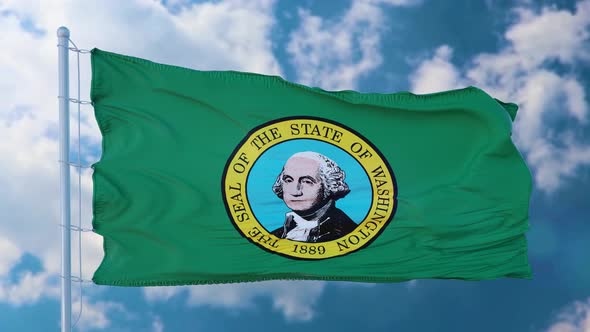 Washington State Flag on a Flagpole Waving in the Wind Blue Sky Background