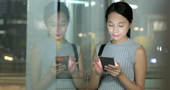 Woman using mobile phone in evening 