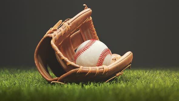 Vintage leather baseball glove with a ball lying down in a stadium spotlight 4K