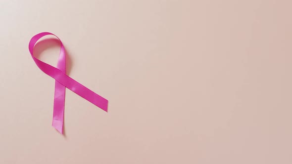 Video of pink breast cancer ribbon on pale pink background
