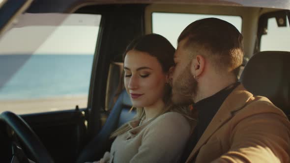 Engaged couple are cuddling in the car