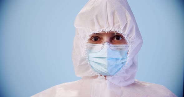 Blured Doctor or Nurse Wearing Personal Protective Equipment and Holding Syringe of Corona Covid19