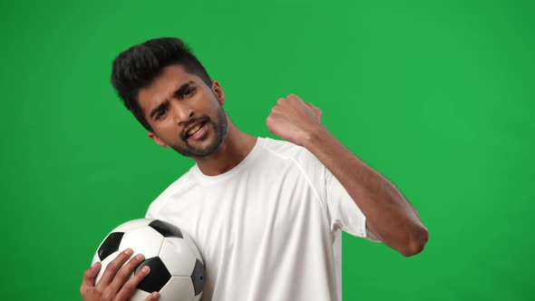 Inspired Middle Eastern Man Gesturing Yes Posing at Chromakey Background with Football Ball