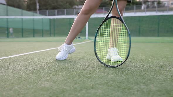 Girl turns a racket on a tennis court
