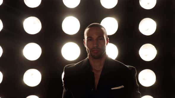 Handsome and stylish man in front of a wall of lights