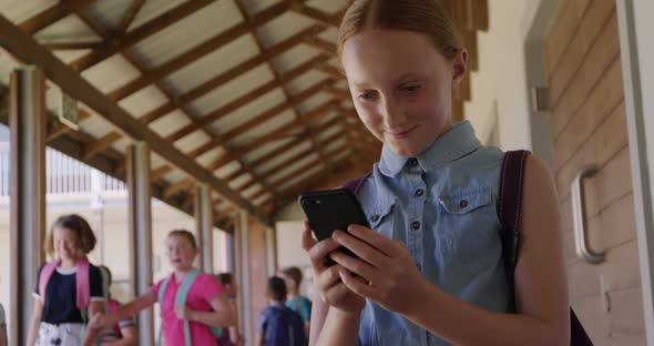 Girl using smartphone in the school corridor