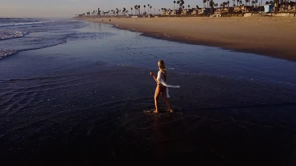 Attractive Blond Woman Walking on the Beach