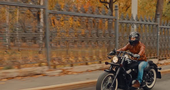 Brutal Man Races on a Bike Along a Beautiful Fence