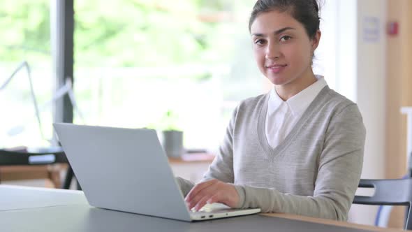 Indian Woman with Laptop Looking at the Camera at Work